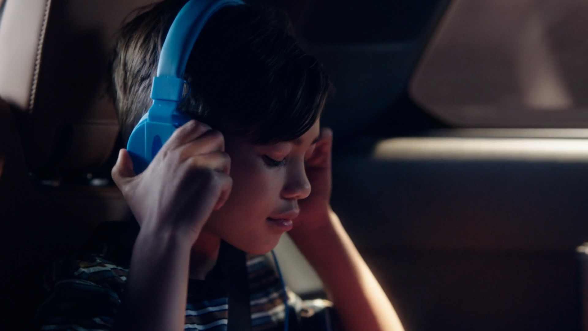 Girl listening with headphones in the 2023 INFINITI QX60 Crossover